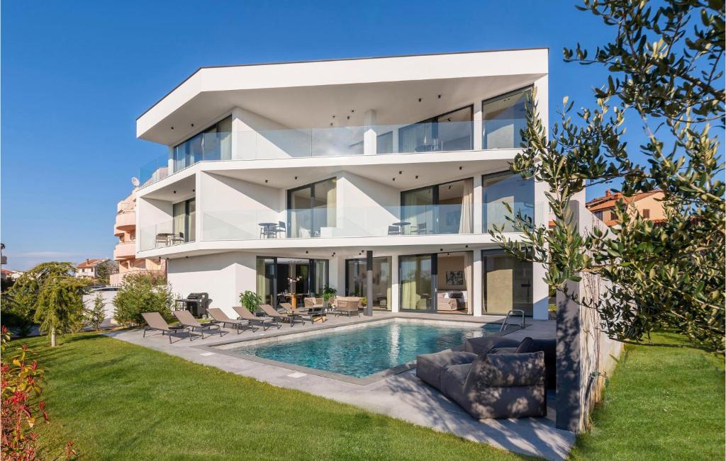 a large white house with a swimming pool at Nice Home In Pula With Kitchen in Štinjan