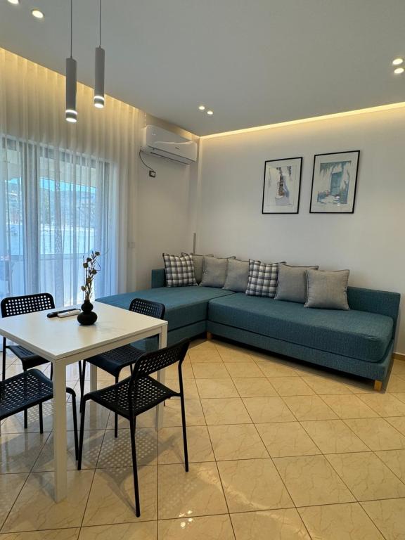 a living room with a blue couch and a table at Villa White in Ksamil