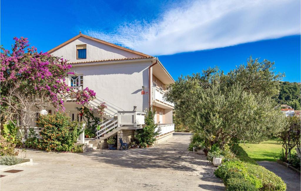 a white house with trees and bushes at Awesome Apartment In Rab With Wifi in Rab