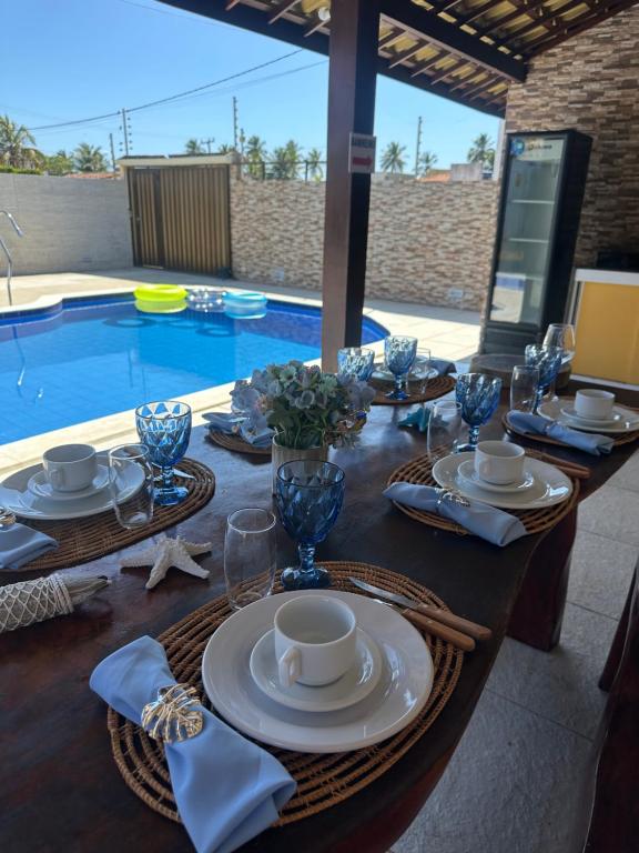 ein gedeckter Tisch für eine Mahlzeit neben einem Swimmingpool in der Unterkunft Casa de praia barra Serinhaém,Carneiros,ilha santo aleixo in Sirinhaém