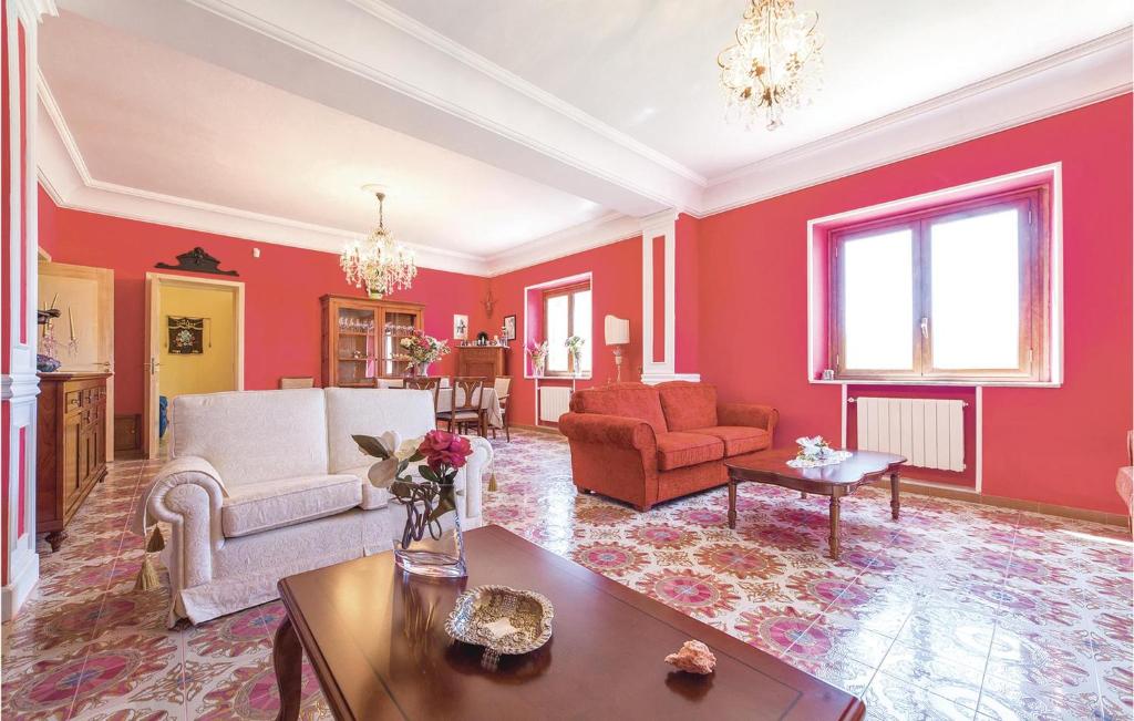 salon z czerwonymi ścianami i stołem w obiekcie Villa Gaia w mieście Menfi
