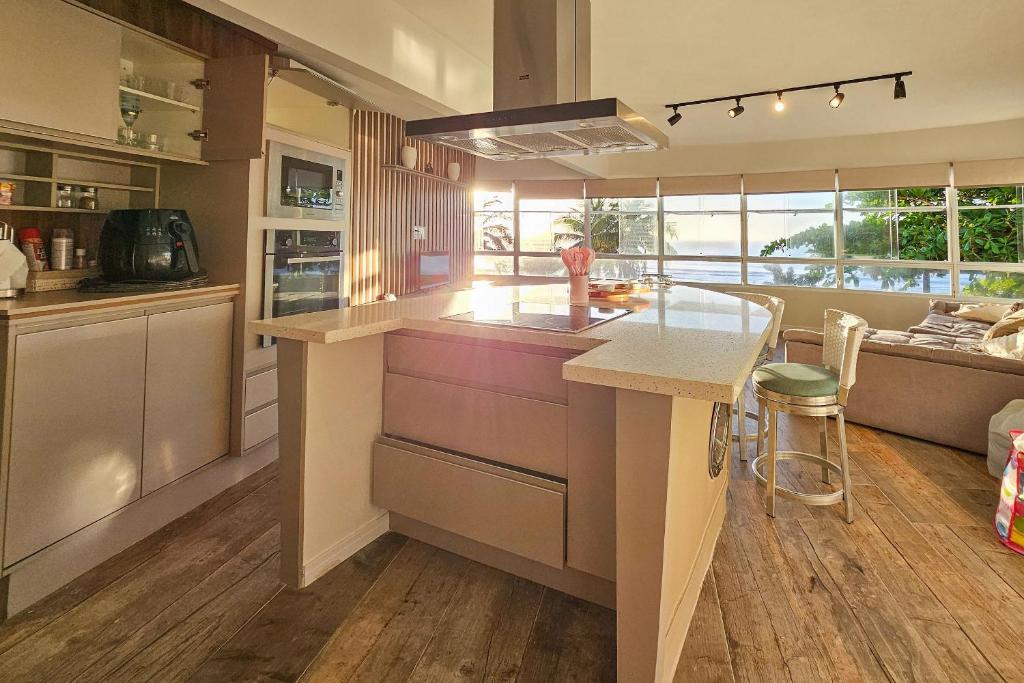 eine Küche mit einer großen Insel in einem Zimmer in der Unterkunft 25C - Pé na Areia do Tombo, 1 Suite Master, Ar Cond, 2Wc, 1 vaga, Roupa de Cama e Vivo fibra in Guarujá