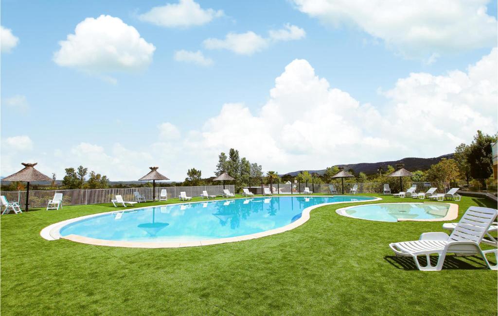 a large swimming pool with chairs and a lawn at 2 Bedroom Awesome Home In Grospierres in Grospierres
