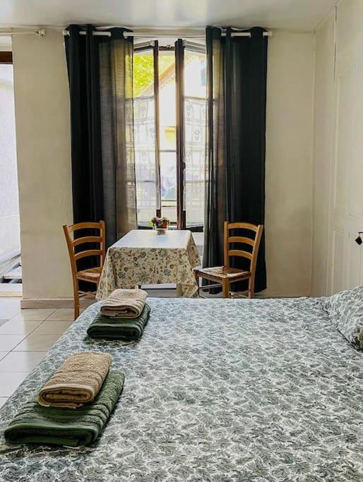 une chambre avec un grand lit avec deux serviettes dessus dans l'établissement L'Aquarium, parking gratuit, garage moto et vélo, à Talloires