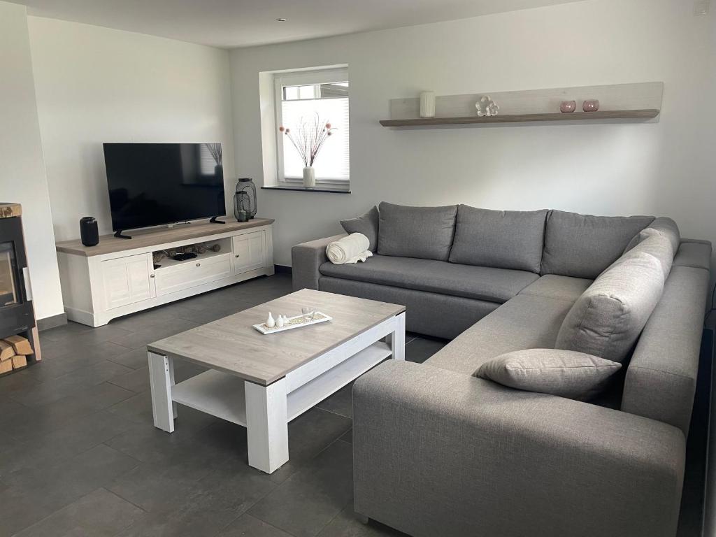 una sala de estar con un sofá y una mesa en Ferienwohnung Biggesee, en Drolshagen