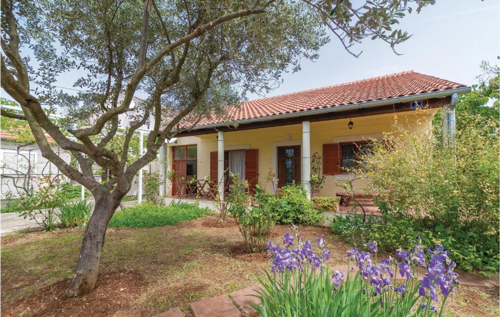 a yellow house with purple flowers in front of it at Holiday Home Put Vrljuge Iv in Sukošan