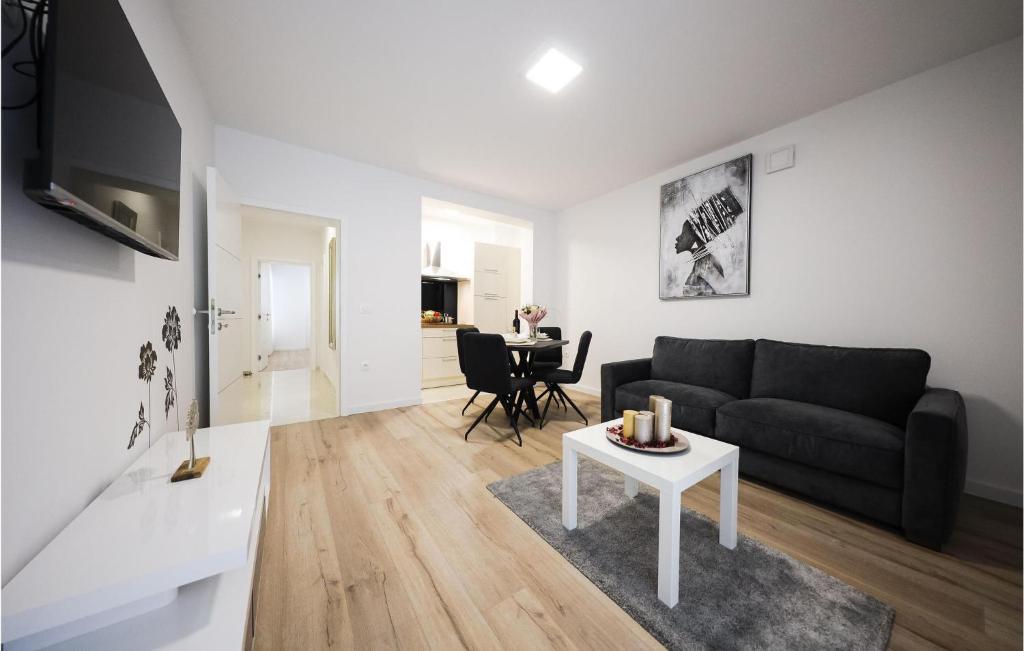 salon z czarną kanapą i stołem w obiekcie 1 Bedroom Lovely Apartment In Zadar w mieście Zadar
