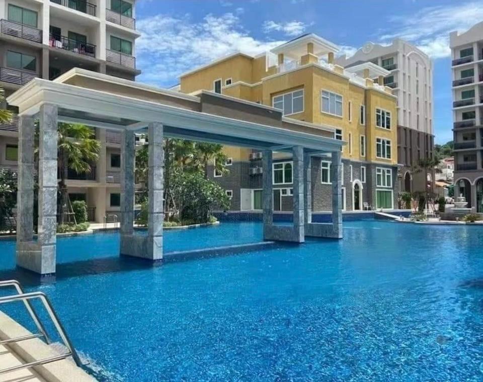 a swimming pool with blue water in a building at Condo Arcadia Beach jomtien pattaya in Pattaya South
