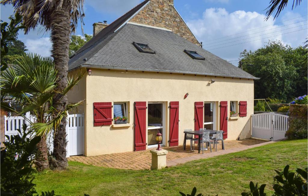 une maison avec des portes rouges et une table dans l'établissement 3 Bedroom Awesome Home In Lézardrieux, à Lézardrieux
