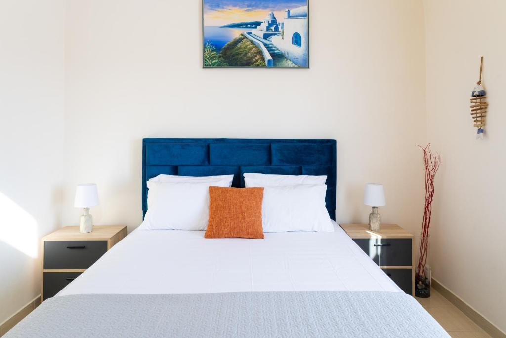 a bedroom with a large bed with a blue headboard at Villa Bonita Private Traditional house in Kamari