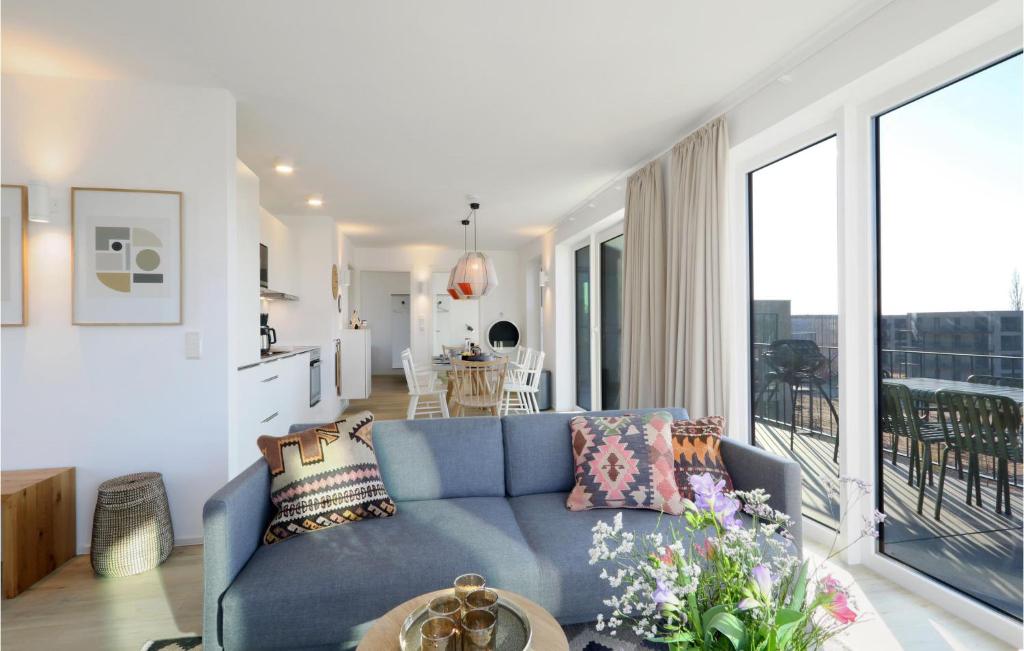 a living room with a blue couch and a balcony at Penthouse Comfort in Lembruch