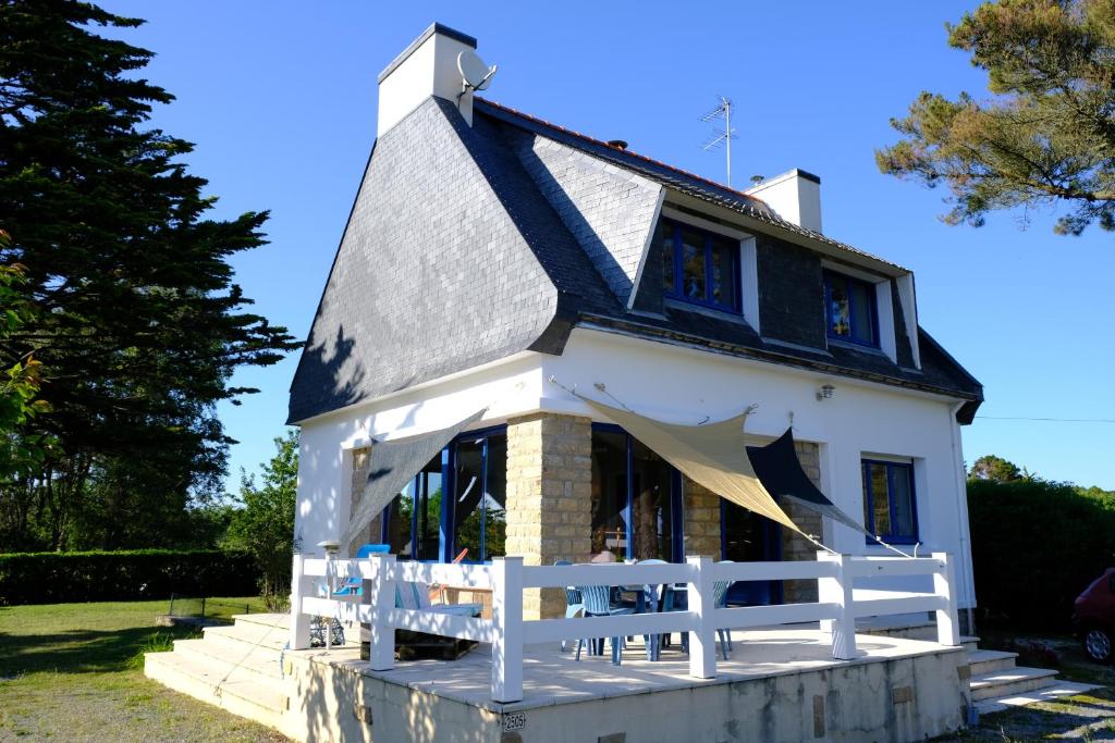 une maison avec une clôture blanche devant elle dans l'établissement Maison 100m de la plage, à Trégunc