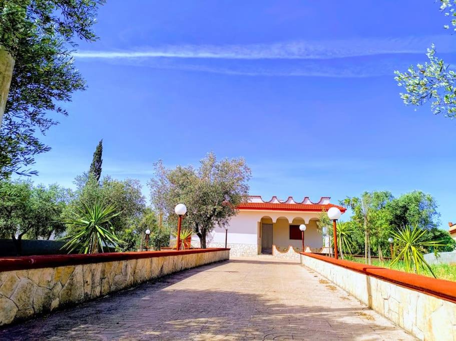 a road leading to a building with a fence at Villa Vento del Sud in Villa Castelli