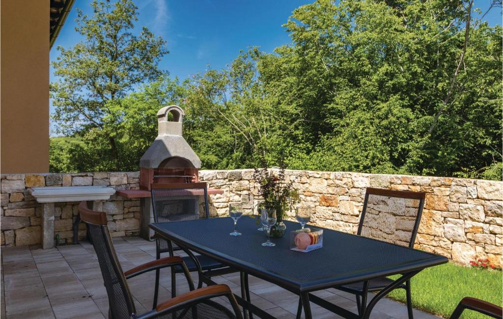 patio ze stołem i kamienną ścianą w obiekcie Awesome Home In Putini w mieście Šorići