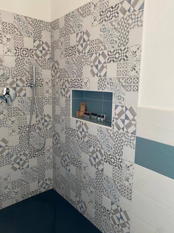 a bathroom with a shower and a tiled wall at L'obiettivo in Assemini