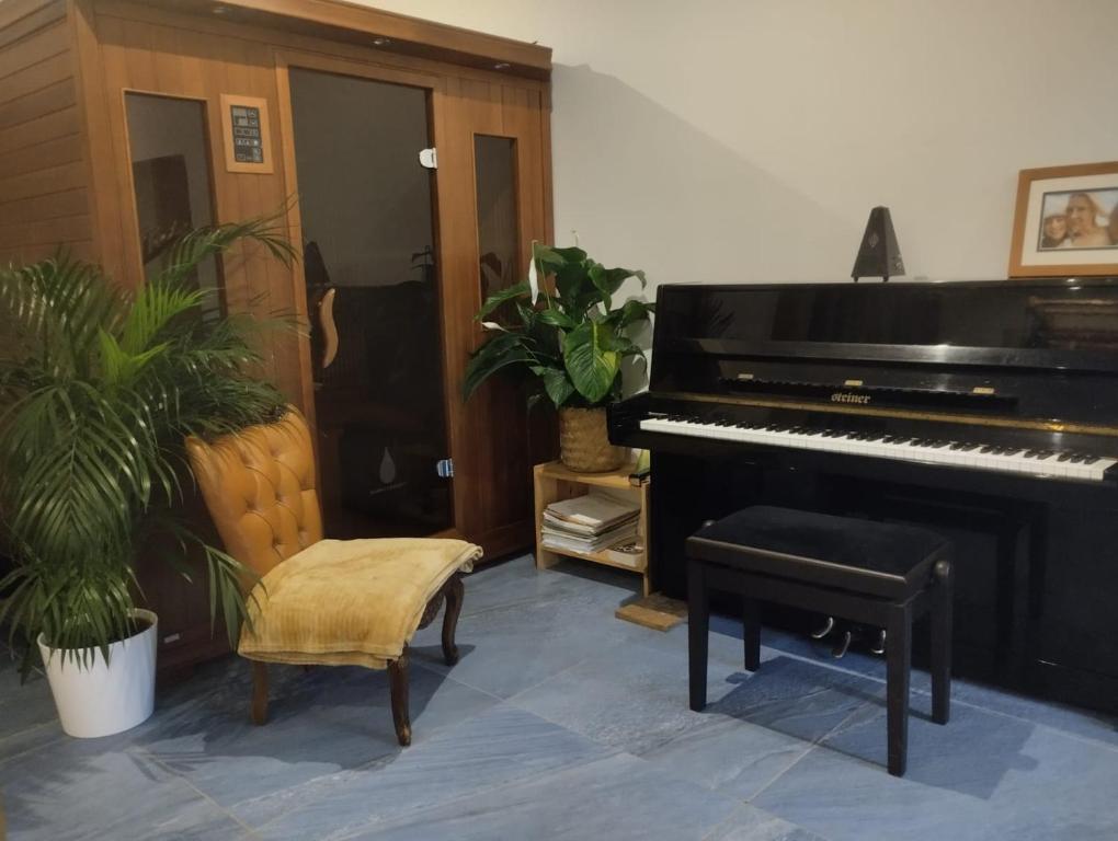- un salon avec un piano et une chaise dans l'établissement Chambre avec grand bureau sdb partagée, à Chavagne