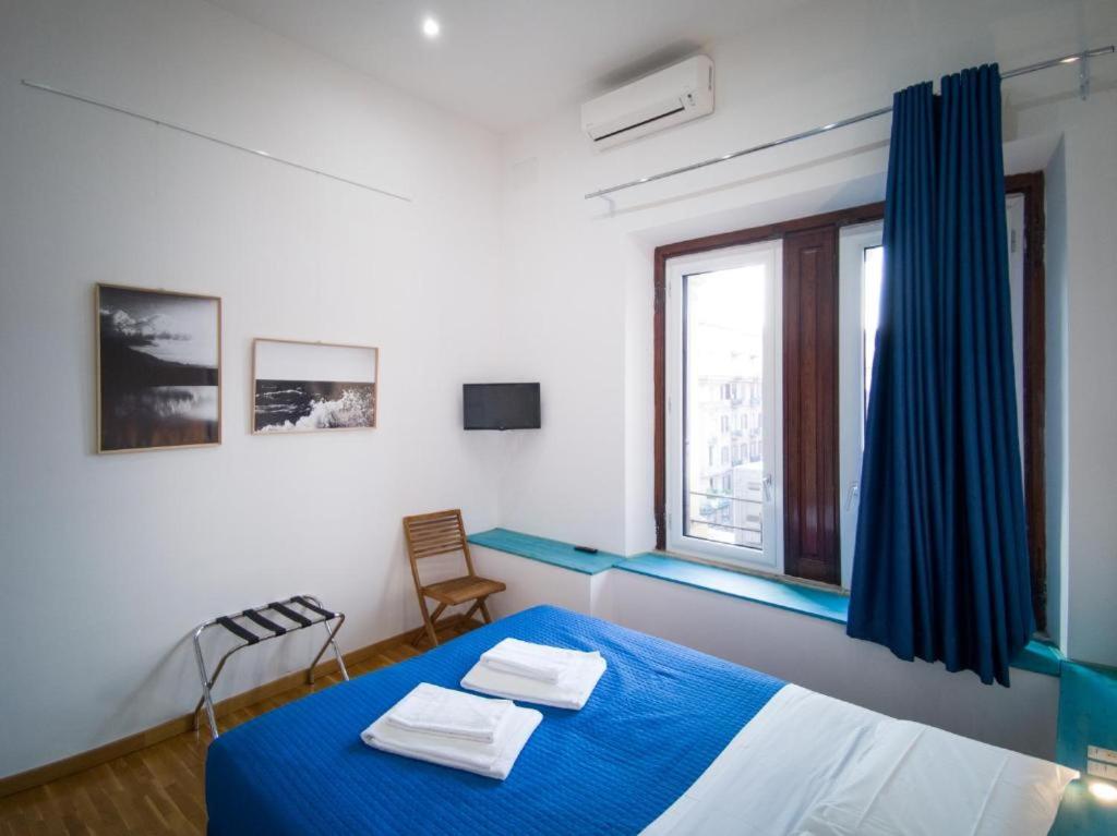 a bedroom with a blue bed and a window at Maison Arena Bovio in Naples