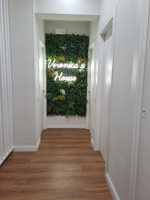 un pasillo con una pared verde con un cartel de bienvenida en Veronica' s house, en Nápoles