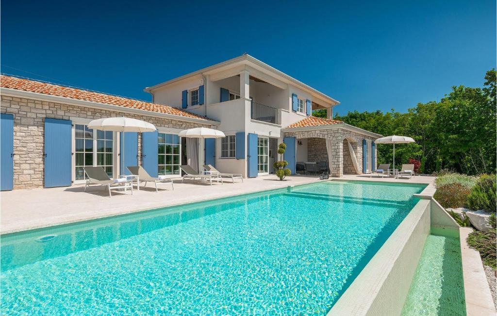 une villa avec piscine devant une maison dans l'établissement Villa Carinzia, à Poreč
