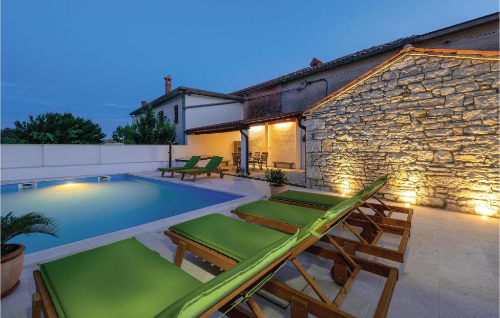 a swimming pool with lounge chairs and a house at Cozy Home In Hreljici in Hreljići