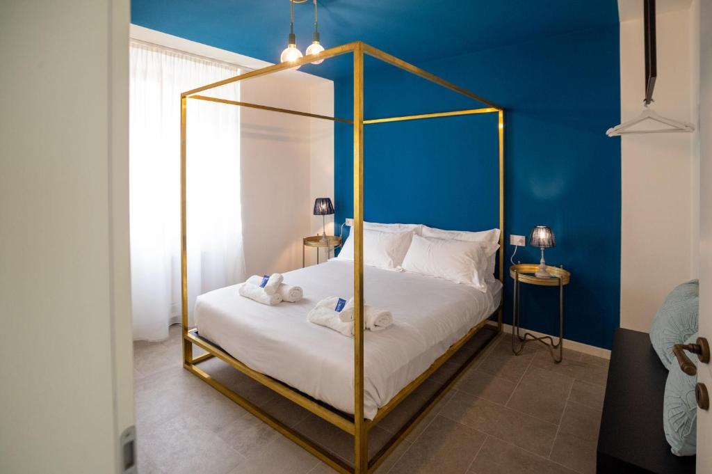 Le Cornici Home Suites - Apartments - Lake Idro في Ponte Caffaro: غرفة نوم مع سرير مغطى بجدار ازرق