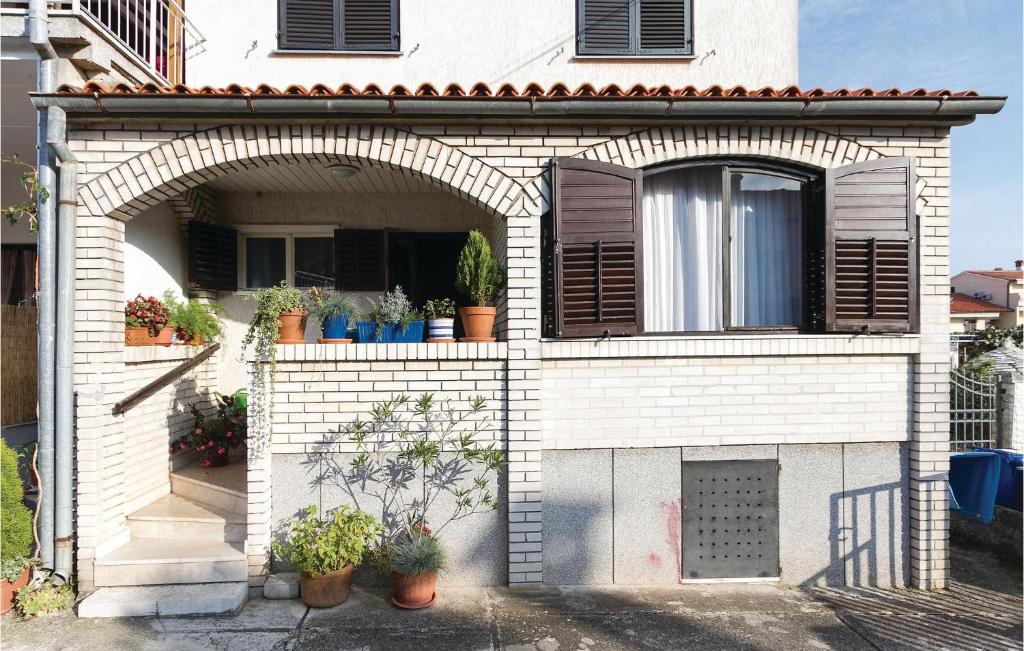 budynek z łukiem i roślinami doniczkowymi w obiekcie 2 Bedroom Lovely Apartment In Rovinj w Rovinj