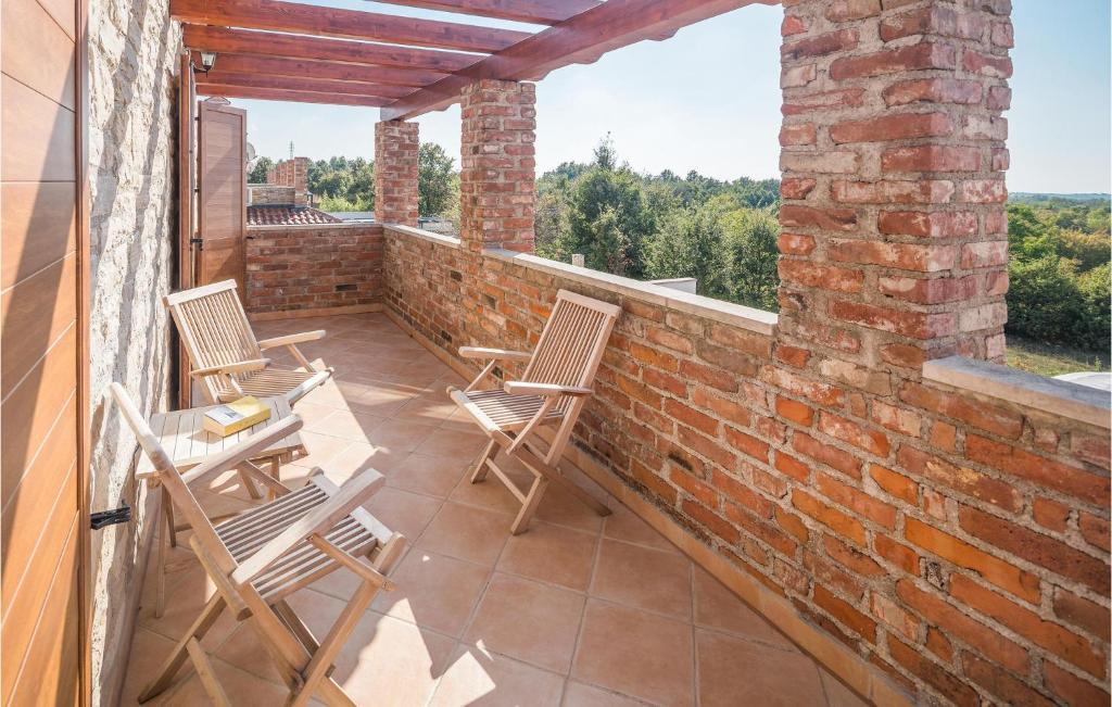 balkon z krzesłami i ceglaną ścianą w obiekcie Gorgeous Home In Cabrunici With Wifi w mieście Čabrunići