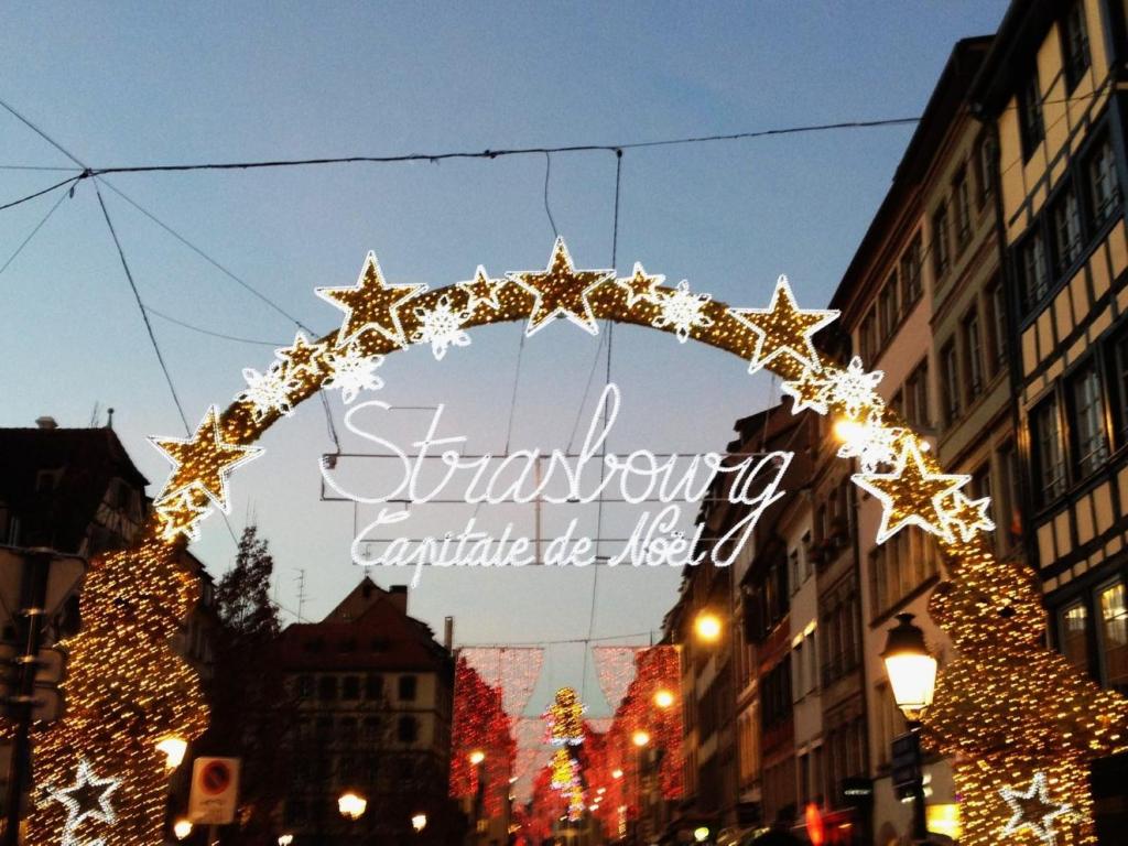 a lit up arch in a city with christmas lights at Le repos Alsacien in Schiltigheim