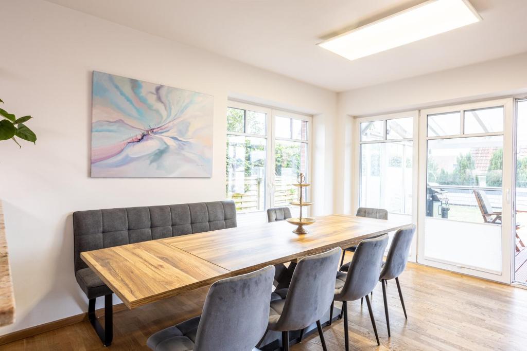 a dining room with a wooden table and chairs at Traumhaus mit Garten in Reppenstedt