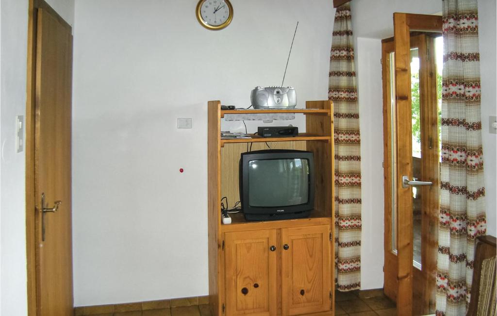 mały telewizor siedzący na drewnianej szafce w pokoju w obiekcie Ansprechende Ferienwohnung w mieście Brixlegg