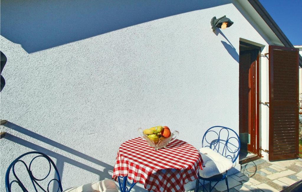 stół i krzesła z miską owoców w obiekcie Awesome Apartment In Umag With Wifi w mieście Umag