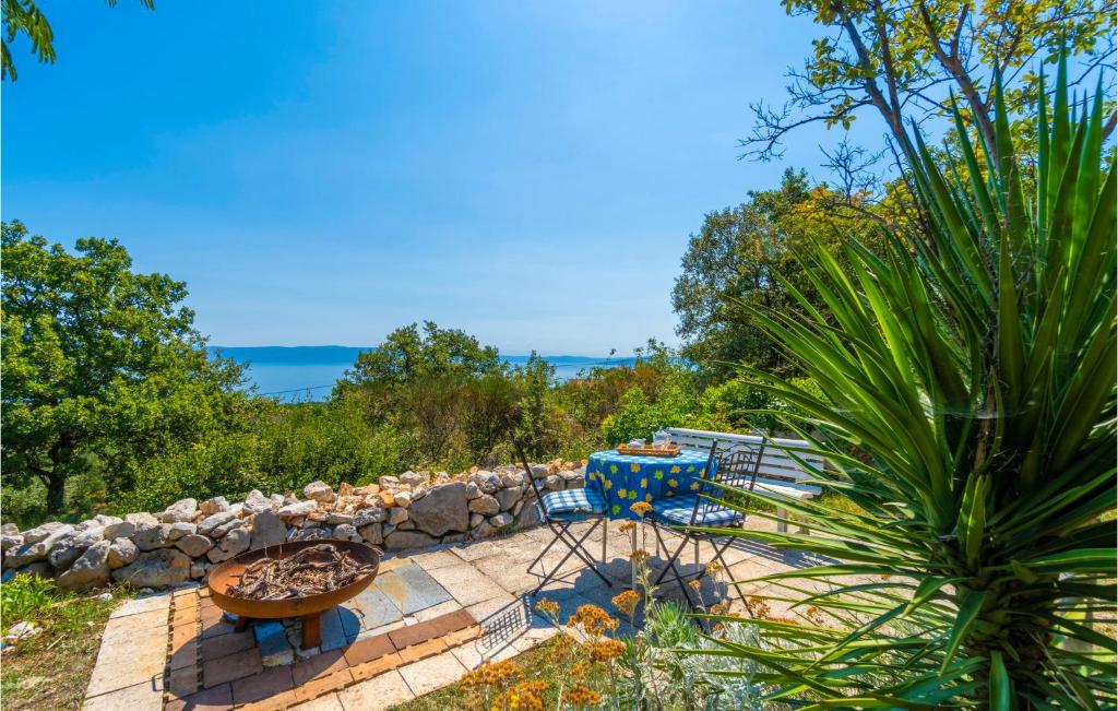 patio ze stołem i krzesłami oraz kamienną ścianą w obiekcie Holiday Home Labin 57 w mieście Drenje
