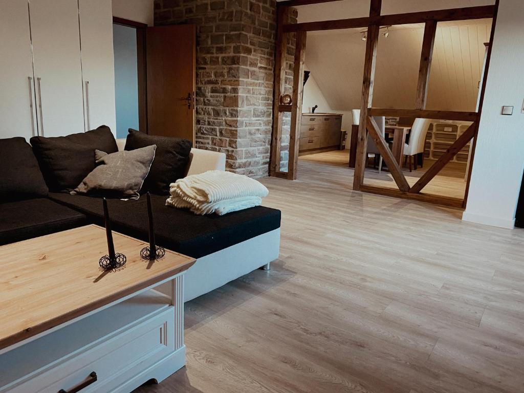 a living room with a black couch and a brick wall at Ferienwohnung de Flingou in Rüber