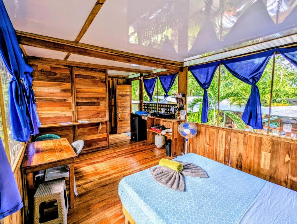 ウビタにあるArboura Eco Cabinsの青いカーテンが備わるベッドルーム1室です。