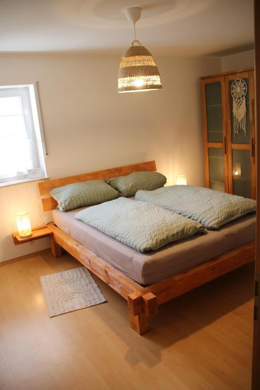 a bedroom with a wooden bed with a pendant light at FeWo Hotzelche in Boppard