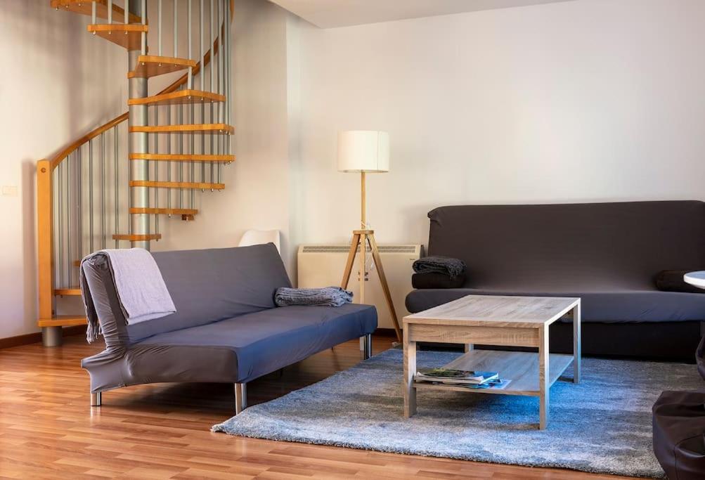 a living room with a couch and a coffee table at Espacioso y luminoso duplex con buhardilla in Valdelinares