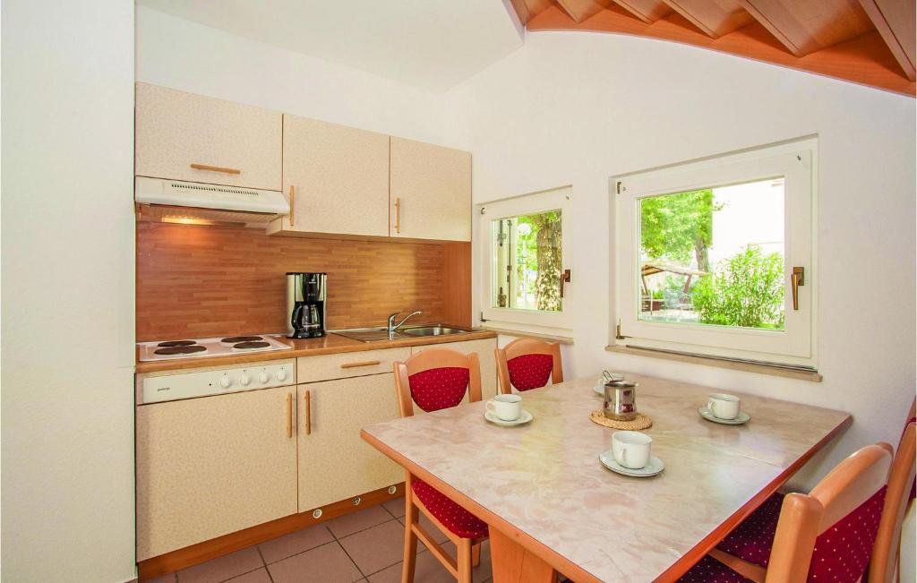 kuchnia ze stołem i krzesłami oraz oknem w obiekcie Awesome Apartment In Baska With Wifi w Bašce