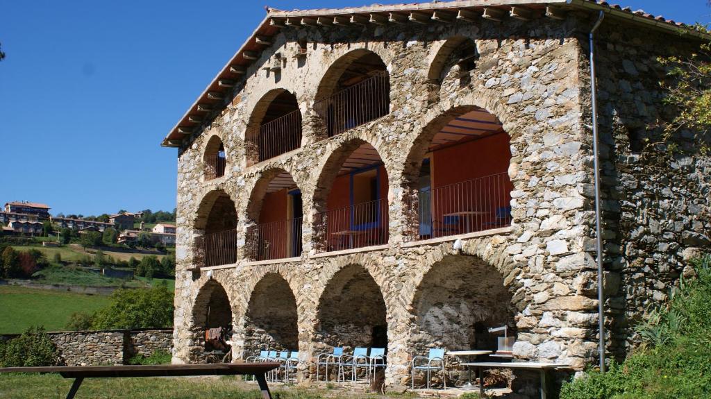 un edificio de piedra con una mesa de picnic delante de él en La Costa de Molló, en Molló