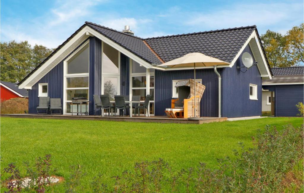 a blue house with a patio and green grass at Amazing Home In Krems Iiwarderbrück in Göls