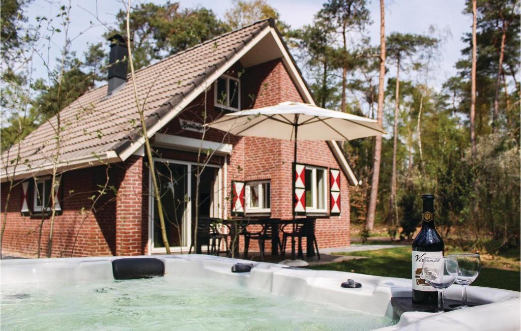 een fles wijn en een parasol naast een huis bij Houtsnip in Ommen