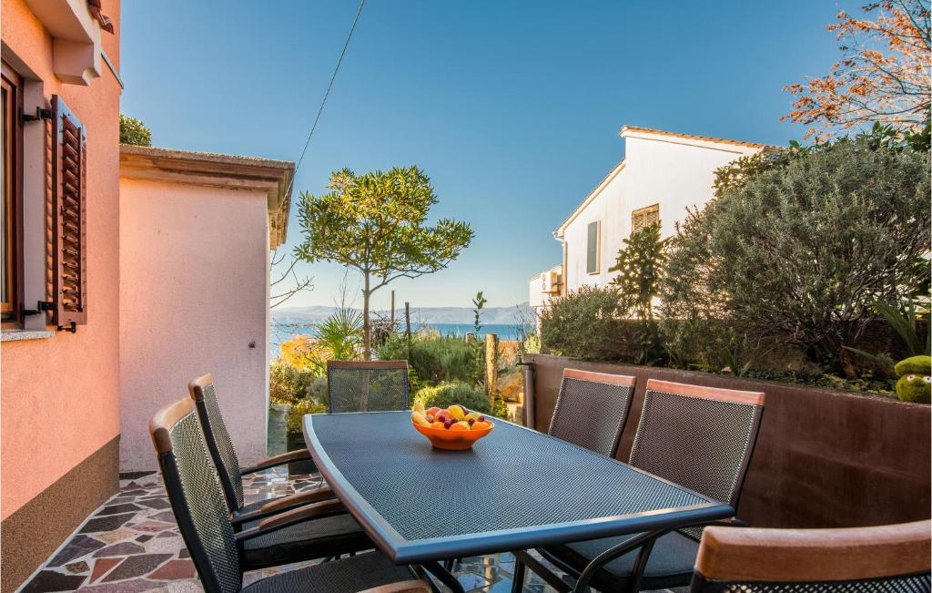 a blue table with a bowl of fruit on a patio at Stunning Apartment In Njivice With Wifi in Njivice