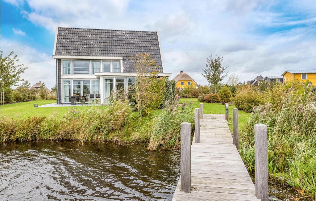 una casa en el agua con un muelle de madera en Grote Wiedenwoning 6P, en Giethoorn