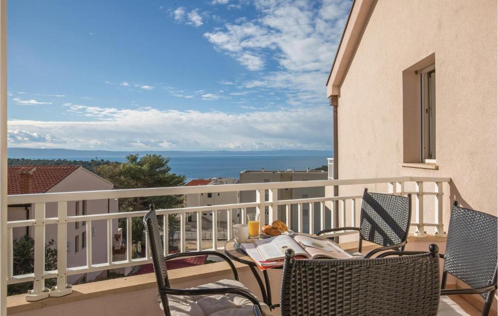a balcony with chairs and a table with a view of the ocean at Apartment Vukovarska Iii in Makarska