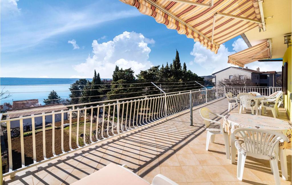 balkon ze stołami i krzesłami oraz widokiem na ocean w obiekcie Nice Apartment In Maslenica w mieście Maslenica