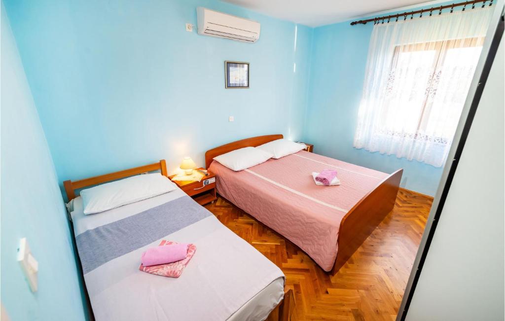 2 łóżka w pokoju z niebieskimi ścianami w obiekcie Nice Apartment In Maslenica w mieście Maslenica