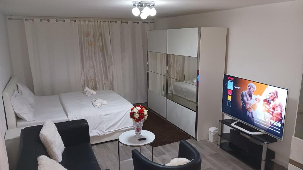 a small room with a bed and a tv at Gemütliches Loft 150 m von SLK klinikum Böckingen in Heilbronn
