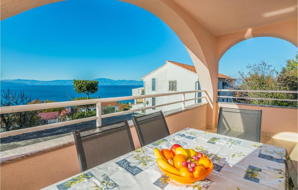 a table with a bowl of fruit on a balcony at 2 Bedroom Nice Apartment In Njivice in Njivice