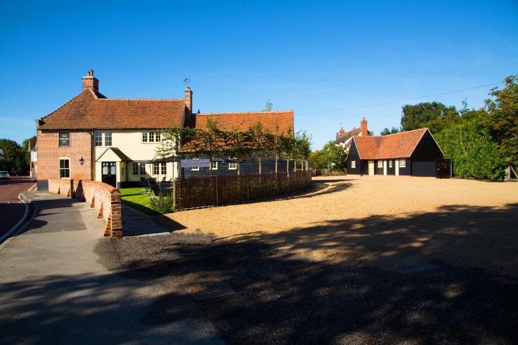 a group of houses and a driveway with a fence at The Harvard Inn in Stock