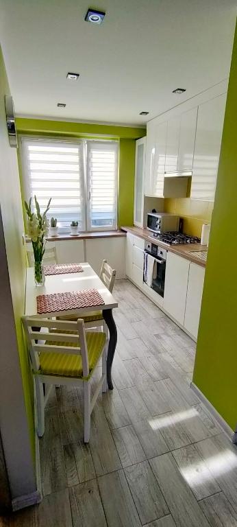 a kitchen with a table and a bench in it at Apartament Bella Zdrój in Głuchołazy