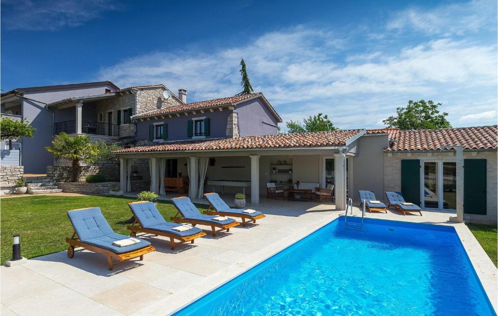 een zwembad met stoelen en een huis bij Villa Pepi in Pulići